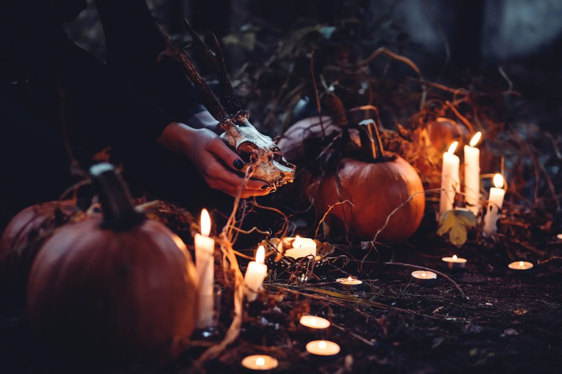 Person decorating pumpkins and candles