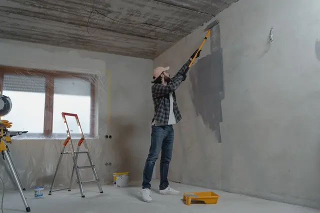 Man painting a house wall