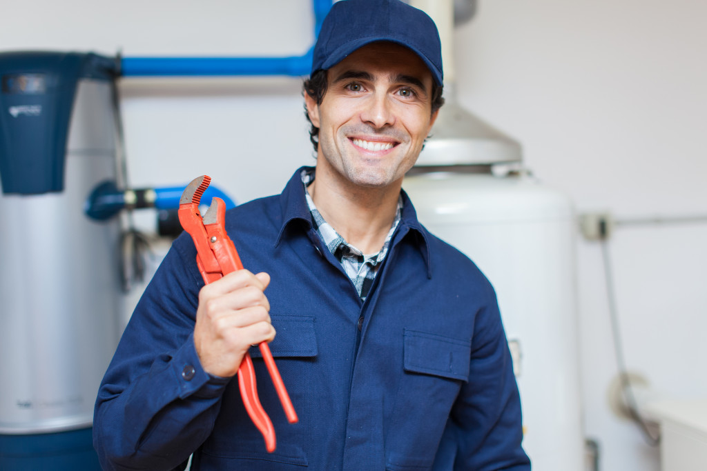 smiling male plumber with a tool