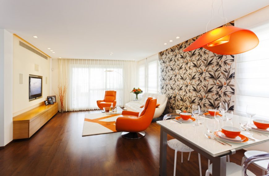 a beautifully-designed lviing room with orange utensils and chairs